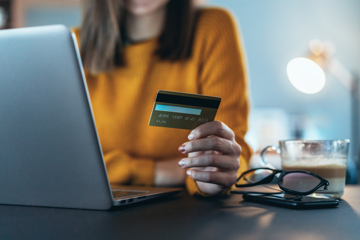A customer paying with a gold credit card next to a laptop